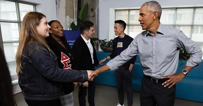 A picture of Rhea Carter shaking hands with former president Barack Obama in a social setting.