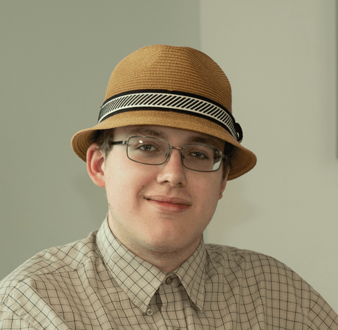 Image of Berea College student, Sam, smiling at the camera wearing a hat