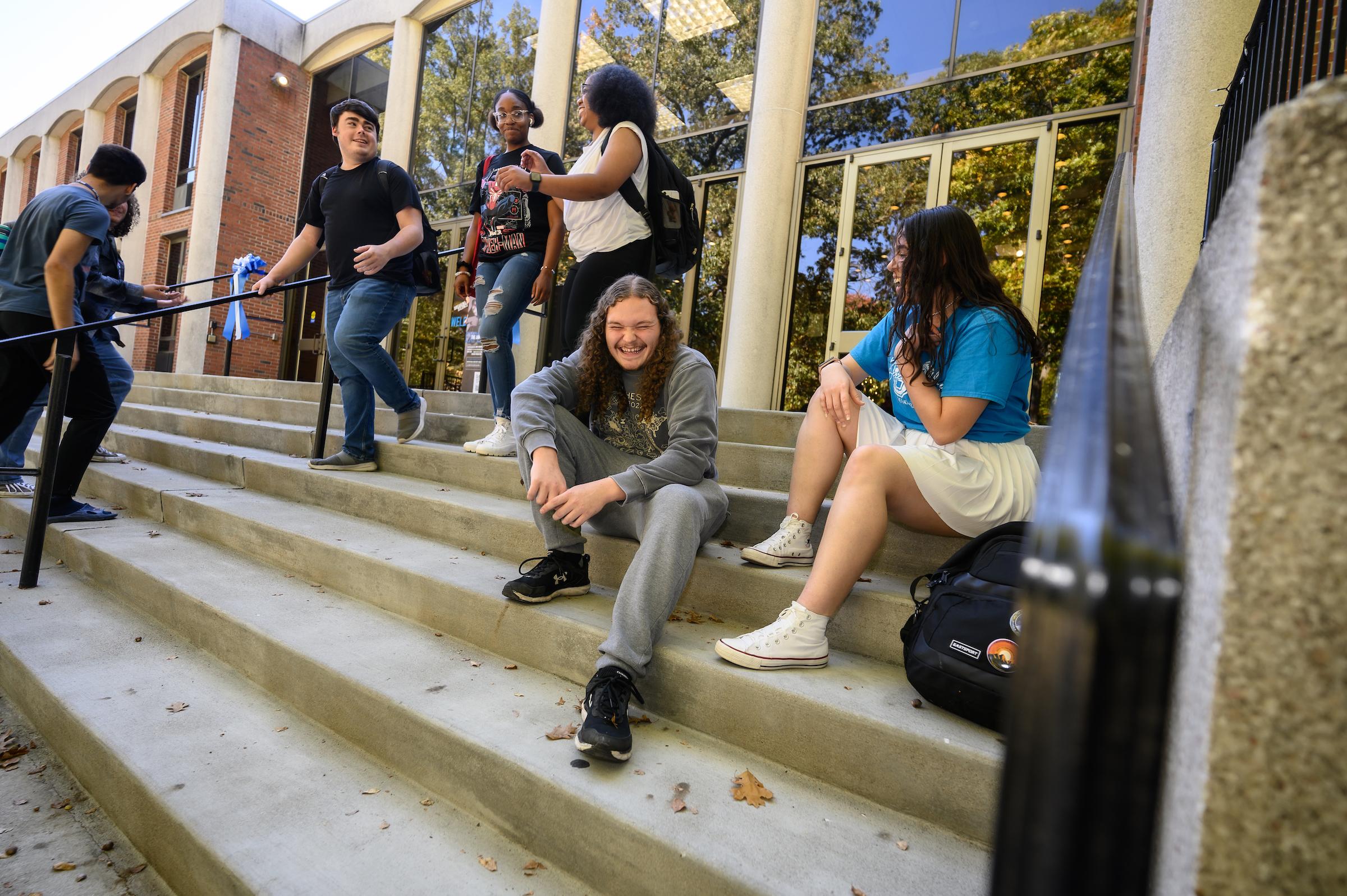 Students interacting with one another on stairs
